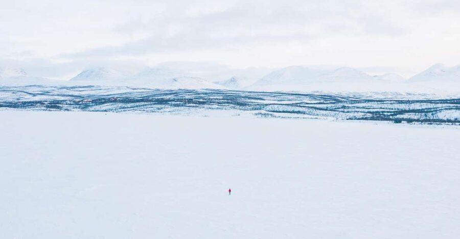 Abisko: Lake Torneträsk Arctic Ice Fishing Trip - Sitting over a hole in Lake Torneträsk country