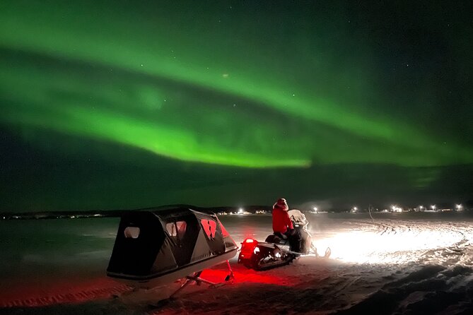 Northern Light snowmobile tour in Kiruna 7:30 pm - Passing the Icehotel beside the Torne River